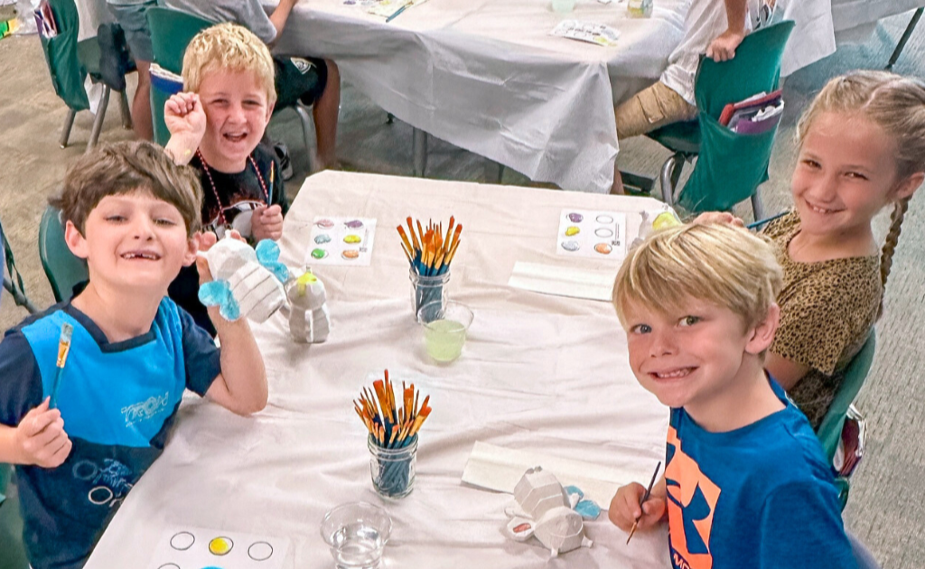 Classroom of kids painting pottery